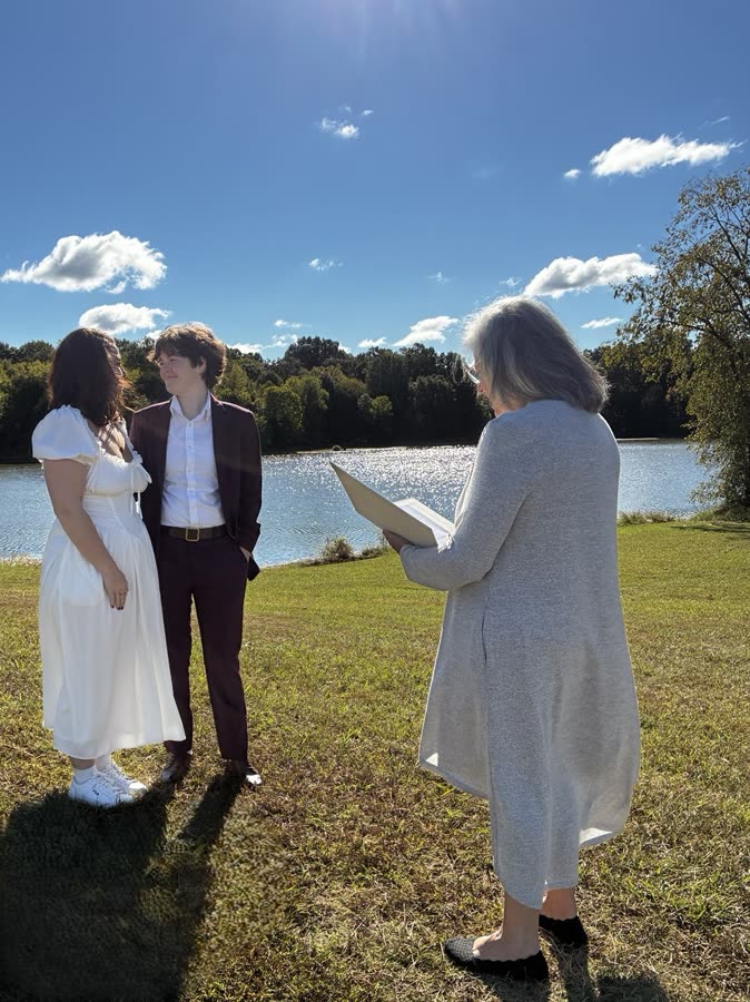 Beth officiating a lakeside wedding ceremony